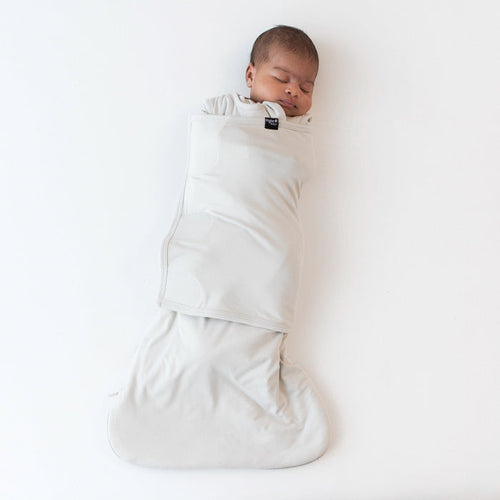 Sleeping baby swaddled in the Sleep Bag Swaddler in Oat 1.0