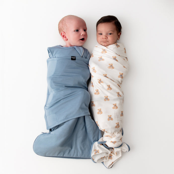 Two babies wrapped in swaddles on a white background