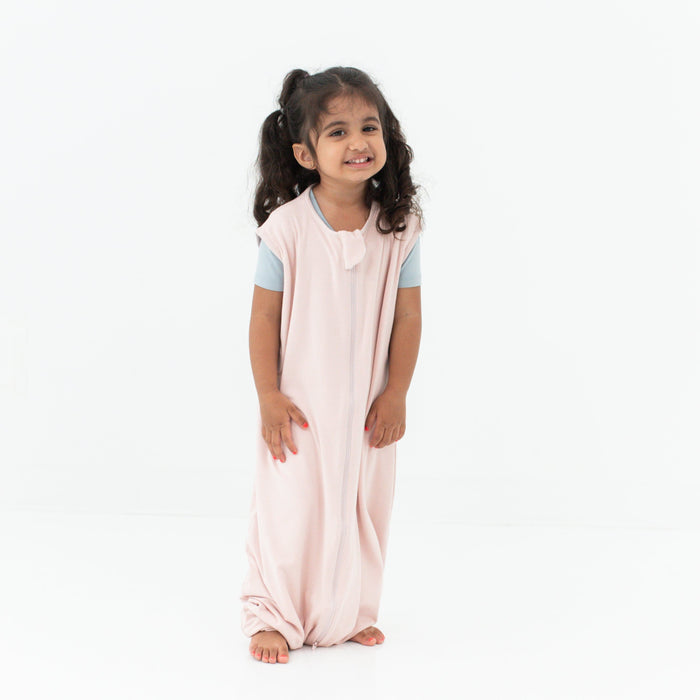 Smiling model wearing the Sleep Bag Walker in Blush 0.5