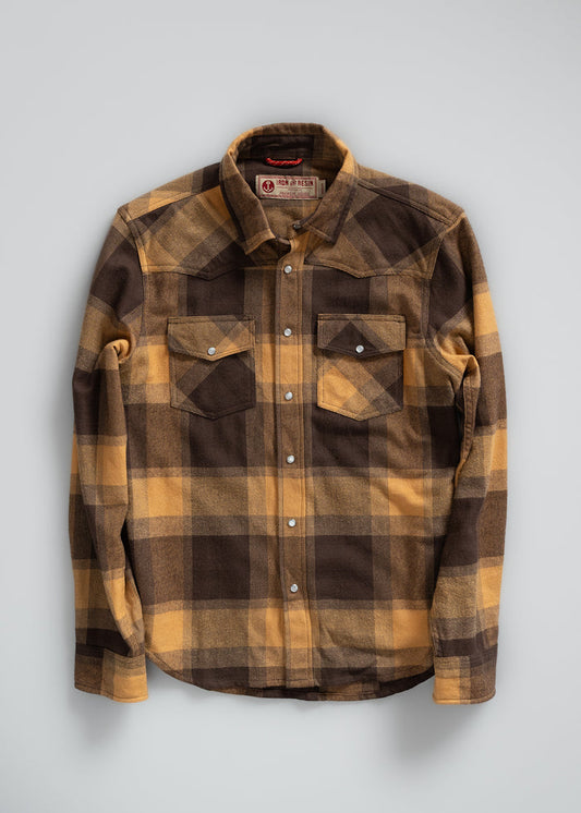 Brown and yellow plaid flannel shirt with snap buttons and two chest pockets, displayed against a plain background.
