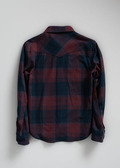 Back view of a long-sleeve, red and blue plaid flannel shirt on a plain background, showcasing its casual style and pattern.