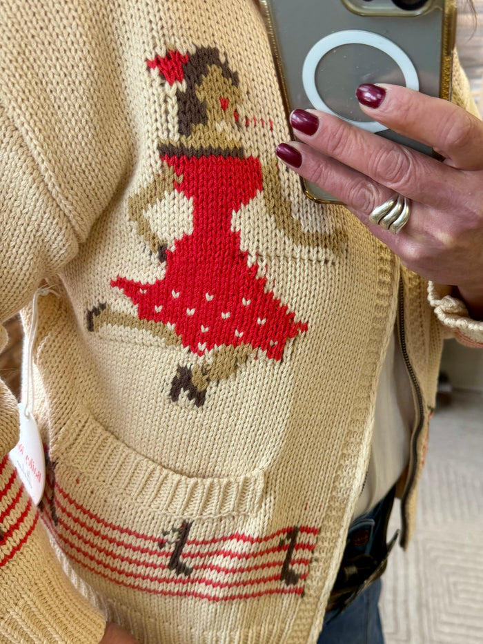 Cream knit cardigan front with red, brown, and beige square-dance patch detail