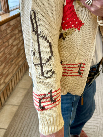 Cream knit cardigan sleeve with square-dance themed knit figures and striped cuffs
