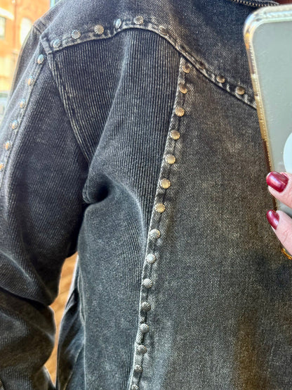 Studded button placket detail on dark charcoal 1/4-zip sweatshirt