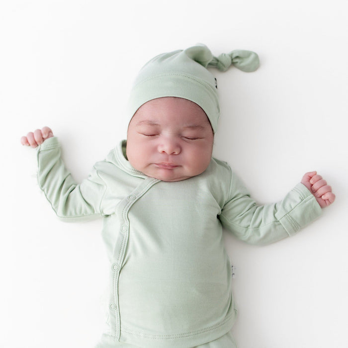 Close up of sleeping newborn wearing the Take Me Home Set with Cap in Basil