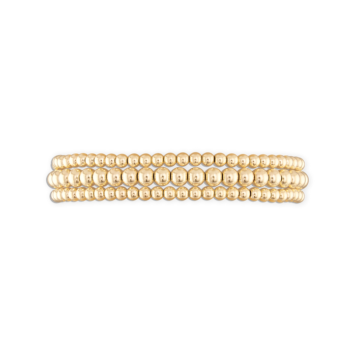 A stack of three gold-colored ball bracelets with an elastic stretch band.