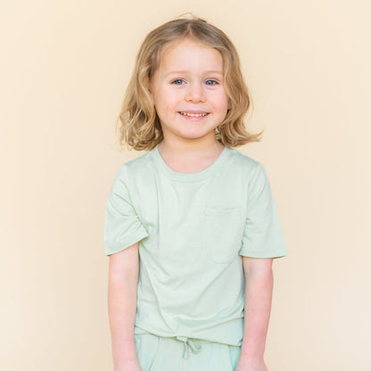 Young child modeling the Toddler Crew Neck Tee in Basil paired with matching drawstring shorts