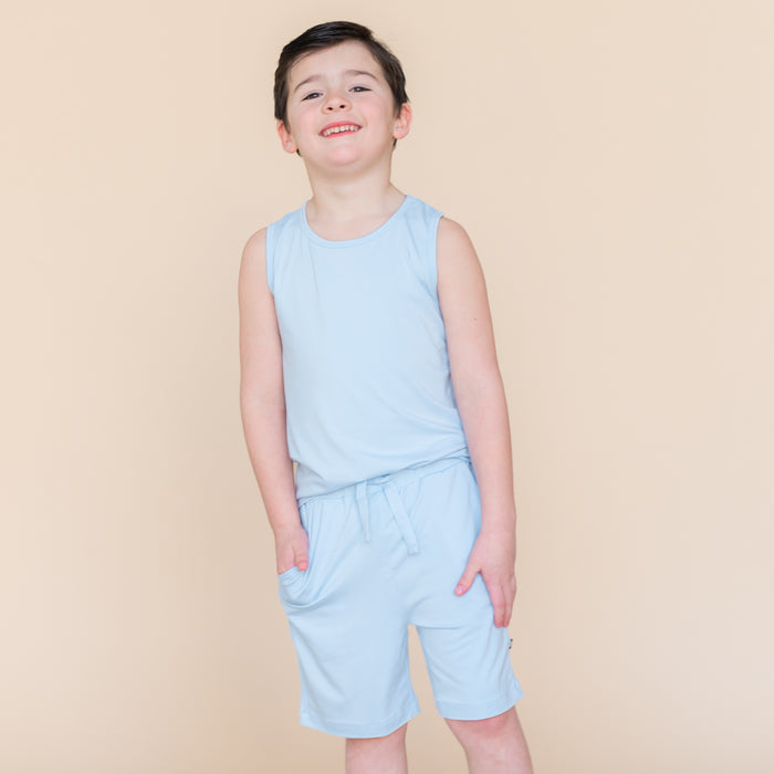 Young smiling boy wearing the Toddler Tank Top in Breeze paired with matching drawstring shorts