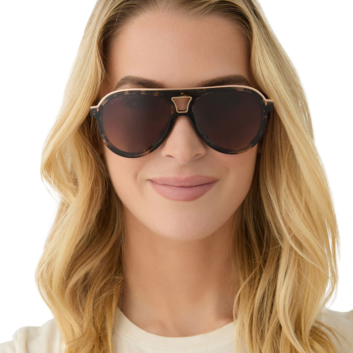 on model - female wearing diff eyewear featuring the tosca iii aviator sunglasses with a espresso tortoise frame, gold temple and rim and brown gradient polarized lenses front view