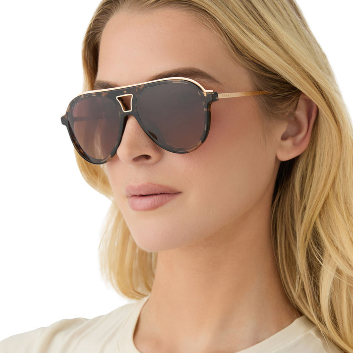 on model - female wearing diff eyewear featuring the tosca iii aviator sunglasses with a espresso tortoise frame, gold temple and rim and brown gradient polarized lenses side view