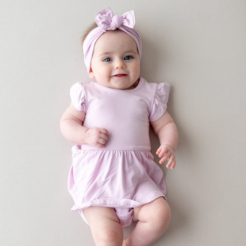 Baby wearing a light purple twirl bodysuit dress with matching bow