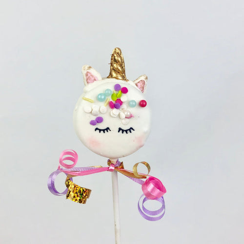 Chocolate covered Oreo decorated like a unicorn. The stick is wrapped with ribbons.