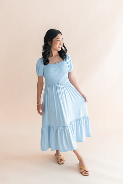 Female modeling the Women’s Smocked Dress in Breeze in front of  a light neutral background